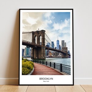 Può includere: Stampa incorniciata con il ponte di Brooklyn a New York City. L'immagine mostra il ponte sull'acqua con lo skyline della città sullo sfondo. La stampa include il testo "BROOKLYN, New York" in basso.