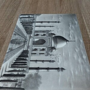 May include: A black and white pencil drawing of the Taj Mahal, a famous mausoleum in India. The drawing depicts the intricate details of the building, including the minarets, domes, and arches. The drawing is done in a realistic style and captures the beauty of the Taj Mahal.