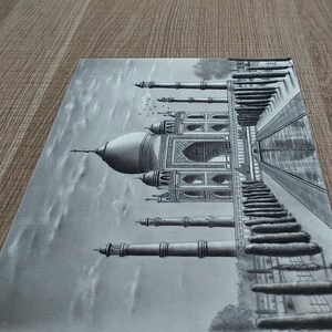 May include: A detailed pencil drawing of the Taj Mahal, a famous white marble mausoleum in Agra, India. The drawing depicts the intricate details of the building, including the minarets, domes, and arches. The drawing is done in shades of grey, creating a realistic and elegant depiction of the iconic landmark.