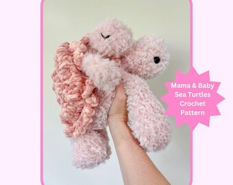 May include: A handmade, plush pink sea turtle with a textured shell and soft, fluffy body. The turtle has a smiling face and is held up in front of a light background. Text on the image reads "Mama & Baby Sea Turtles Crochet Pattern."