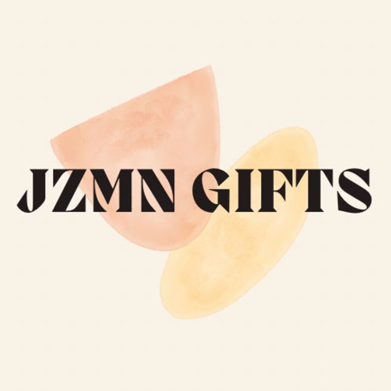 May include: A logo design with the words "JZMN GIFTS" in a bold, black font. The text is set against a cream-coloured background with two abstract watercolour shapes in peach and yellow.
