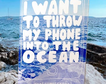 Op de afbeelding: Een rechthoekige kaart met een blauwe oceaan en de witte tekst I WANT TO THROW MY PHONE INTO THE OCEAN. Het ontwerp bevat een witte omtrek in de vorm van een smartphone en de tekst retromaccaroni onderaan in het midden.