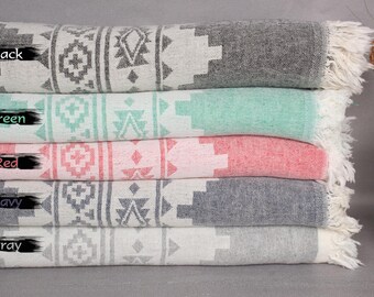 May include: Five Turkish towels stacked on top of each other. The towels are in the colors black, green, red, navy, and gray. Each towel has a white geometric pattern.