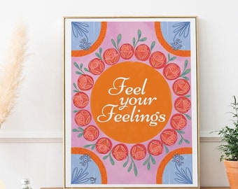 May include: A framed art print with the words "Feel your Feelings" in an orange circle, surrounded by red roses and green leaves. The background is a light pink with blue and orange floral accents. The words "Digital Download" are also visible.