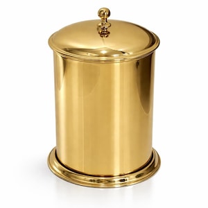 Puede incluir: Un recipiente cilíndrico con acabado en oro pulido, que cuenta con una tapa a juego con un pequeño pomo esférico. El contenedor tiene una superficie lisa y reflectante y se asienta sobre una base circular con un borde escalonado.