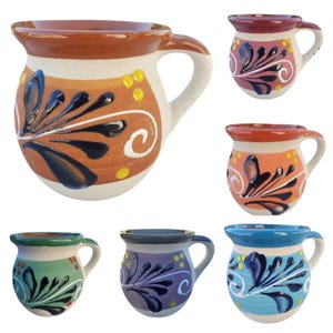 May include: Set of six small ceramic mugs with a white base and a rounded belly. Each mug has a different coloured rim and body, with a black and white floral design. The mugs are perfect for serving coffee, tea, or other beverages.