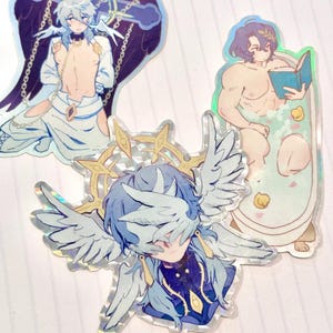 May include: Three holographic stickers featuring anime characters. The first sticker shows a male character with blue hair and wings, the second sticker shows a male character with blue hair and a halo, and the third sticker shows a male character with brown hair in a bathtub.