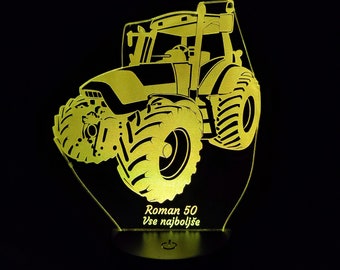 May include: A yellow tractor-shaped LED night light. The tractor is illuminated against a black background. The text "Roman 50 Vse najbolje" is displayed on the base of the light.