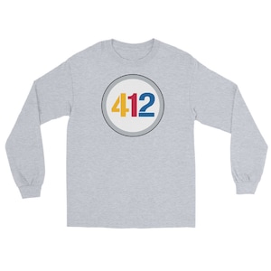 May include: A gray long-sleeve shirt with a white circle containing the number 412 in red, yellow, and blue.