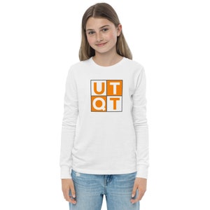 Könnte beinhalten: Weißes Langarm-T-Shirt mit einer orangefarbenen quadratischen Grafik, auf der "UTQT" in weißen Buchstaben steht.
