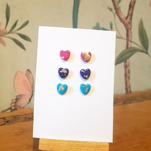 set of 3 bisexual pride earrings, bright pink purple and blue heart shaped polymer clay studs decorated with gold leaf