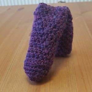 May include: A purple crocheted sock with a textured pattern.