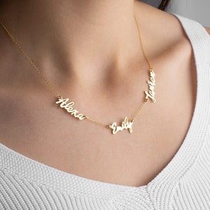 May include: Gold necklace with three names, "Alexa", "Emily", and "Lauren", spelled out in cursive.