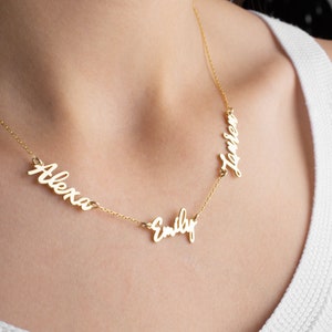 May include: Gold necklace with three names, "Alexa", "Emily", and "Lauren", written in cursive.