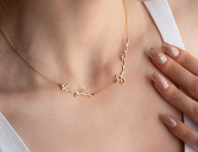 May include: A gold necklace with two names, "Kayla" and "Justin", written in cursive script.