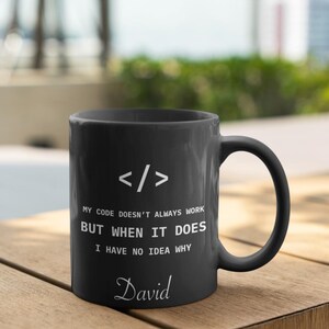 a black coffee mug sitting on top of a wooden table