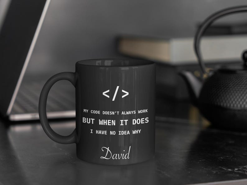 a black coffee mug sitting on top of a table