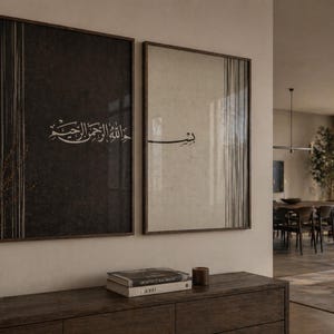 Könnte beinhalten: Zwei gerahmte Wandkunstwerke mit arabischer Kalligraphie. Eines ist dunkel mit weißem Text, das andere ist hell mit schwarzem Text. Beide haben vertikale Linienakzente und werden in einem modernen Wohnraum ausgestellt.