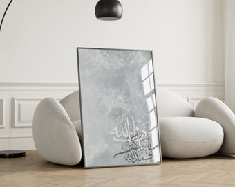 May include: Framed art print with Arabic calligraphy in a modern style. The artwork shows elegant script in grey tones against a textured, light blue and grey background. The print is displayed in a black frame.