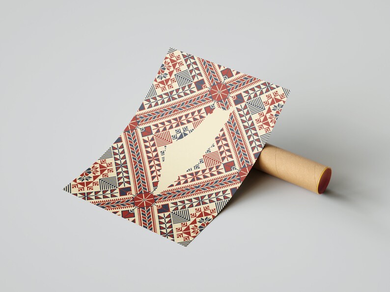 May include: A beige card with a red, blue, and white geometric pattern. The pattern is reminiscent of traditional embroidery. The card is rolled up and partially visible.