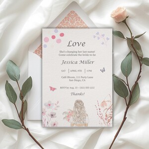 Puede incluir: Una invitación de boda con la palabra "Love" en la parte superior. La invitación incluye el nombre de la novia, la fecha, la hora y el lugar. El diseño presenta detalles florales y de mariposas en acuarela en rosa y morado.