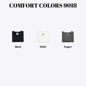 three different colored t-shirts, each with a label indicating the color: black, white, and pepper.