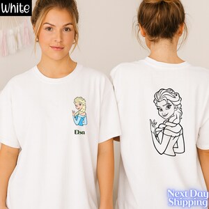 A woman wearing a white t-shirt with a cartoon image of a blonde woman and the name 'Elisa' printed on it.