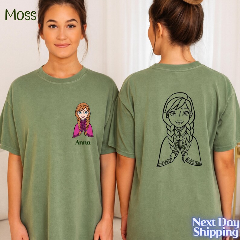 A young woman wearing a green t-shirt with a cartoon character printed on the front and a graphic of a girl on the back.