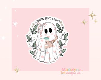 May include: A cute ghost wearing a pink and white patterned dress and holding a cup of pumpkin spice. The ghost is surrounded by green leaves and flowers. The text "Pumpkin Spice Ghouly" is written above the ghost.