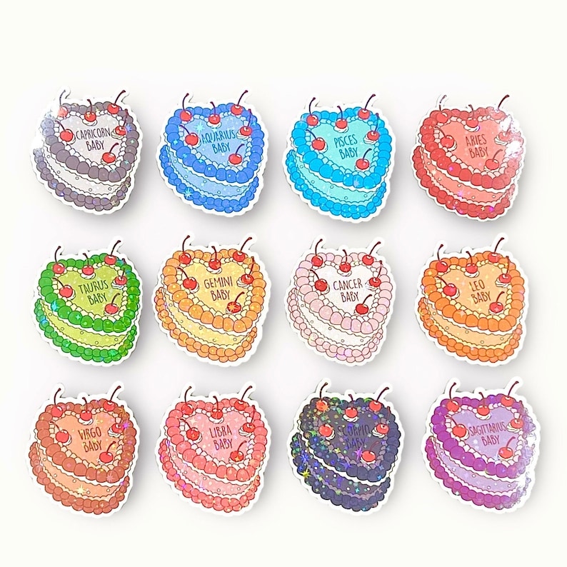 May include: Twelve heart-shaped cake pins with glitter and cherries. Each pin features a different zodiac sign with the text "Baby" underneath. The signs are Capricorn, Aquarius, Pisces, Aries, Taurus, Gemini, Cancer, Leo, Virgo, Libra, Scorpio, and Sagittarius.