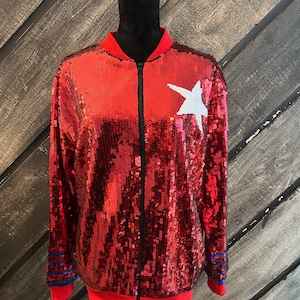 May include: Red sequined bomber jacket with a white star on the front and blue and red stripes on the sleeves.
