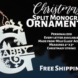May include: White acrylic Christmas bauble with a split monogram design featuring the name "GABBY" and a Santa Claus and reindeer design. The bauble is 4 inches by 5 inches and comes with a red and green string.