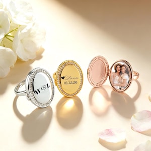 May include: Oval locket rings in silver, gold, and rose gold. One ring displays the initials "W & L", another has the name "Lana" and the date "01.12.26". The rose gold ring opens to reveal a photograph.