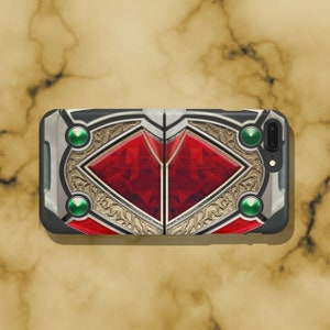 May include: A black phone case with a gold and red design. The design features a large, red gem with intricate gold details and green accents.