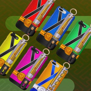 Könnte beinhalten: Eine Sammlung farbenfroher Handyhüllen mit einem Schwertdesign. Die Hüllen sind in verschiedenen Farben erhältlich, darunter Rot, Blau, Grün, Gelb, Pink und Orange. Jede Hülle hat ein schwarzes Band, goldene Akzente und ein silbernes Schwertdesign mit einem goldenen Ring.