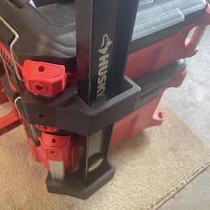 May include: A red and black Husky rolling tool chest with a black handle. The tool chest has red latches and a black top. The Husky logo is visible on the handle.
