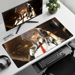 May include: A rectangular desk mat featuring an anime-style illustration of a character with long silver hair, red eyes, and a white uniform with a red tie. The mat is positioned on a white desk alongside a computer monitor, keyboard, and mouse.