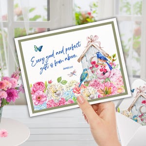 May include: A greeting card featuring a watercolour illustration of a birdhouse, birds, and flowers. The card has the text "Every good and perfect gift is from above." A matching card is in an envelope.