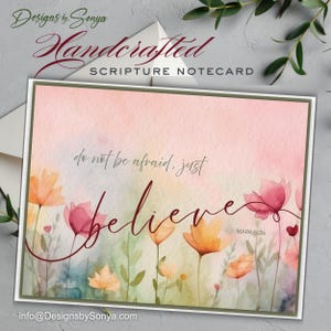 May include: A rectangular notecard featuring a watercolor floral design in shades of pink, orange, and green. The text reads: do not be afraid, just believe, and MARK 5:36. The card has a thin olive green border and is set against a white envelope.