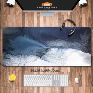 May include: A blue and white abstract design desk mat with a stitched edge. The mat measures 36x16 inches (90x40 cm).