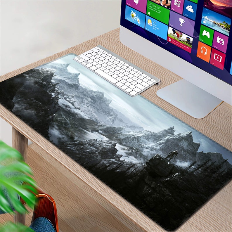 K&ouml;nnte beinhalten: Eine schwarz-wei&szlig;e Mauspad mit einer Berglandschaft. Die Mauspad liegt auf einem Holztisch mit einer Tastatur und einem Computermonitor.
