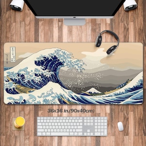 Peut inclure: Un grand tapis de bureau représentant une estampe japonaise sur bois de "La Grande Vague de Kanagawa" de Katsushika Hokusai. Le tapis est beige avec un motif de vague bleu et blanc et mesure 90x40 cm (36x16 pouces).