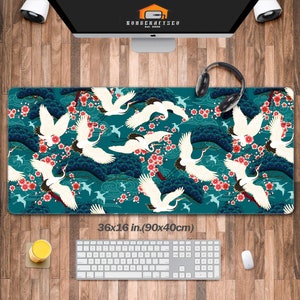 May include: A teal blue mouse mat with a repeating pattern of white cranes flying over a blue and white cloud background with pink cherry blossoms. The mouse mat measures 36x16 inches (90x40 cm).