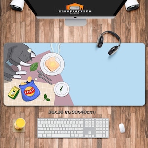 Peut inclure: Un tapis de bureau bleu et rose avec un chat de dessin animé dormant sur une assiette de pain grillé, un sac de chips et une tasse de café. Le tapis mesure 90x40 cm (36x16 pouces).