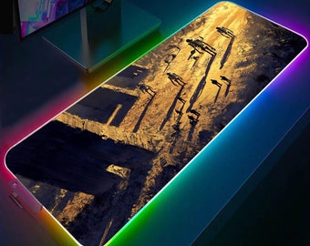 May include: A rectangular gaming mouse pad with a colorful, rainbow-like LED light border. The pad features a dark, detailed image of a post-apocalyptic scene with figures walking along a path.