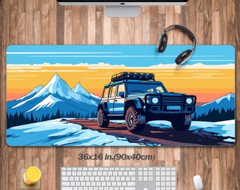 May include: A blue off-road vehicle with a roof rack drives on a snowy mountain road. The vehicle is surrounded by snow-capped mountains and a blue sky with clouds. The scene is set against a sunset backdrop. The mousepad measures 36x16 inches (90x40cm).