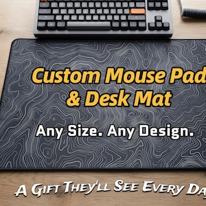 May include: A black desk mat with a white topographic design. The text "Custom Mouse Pad & Desk Mat" is displayed in yellow. The text "Any Size. Any Design." is also visible. A keyboard and mouse are on the desk mat.