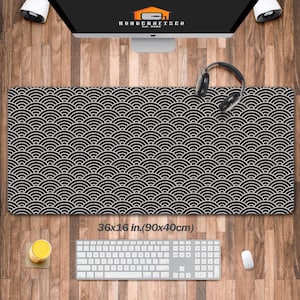 May include: Black and white desk mat with a repeating wave pattern. The mat measures 36 x 16 inches. A keyboard, mouse, and headphones are on the wooden desk. The text "36x16 in.(90x40cm)" is visible.