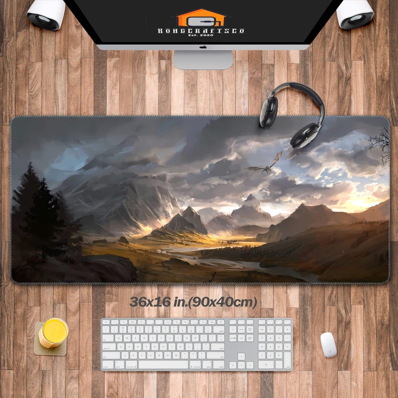 K&ouml;nnte beinhalten: Eine gro&szlig;e, graue und braune Gaming-Mausmatte mit einer Fantasy-Landschaftszene. Die Szene zeigt Berge, einen Fluss und einen Drachen, der am Himmel fliegt. Die Mausmatte ist 36x16 Zoll (90x40 cm) gro&szlig;.