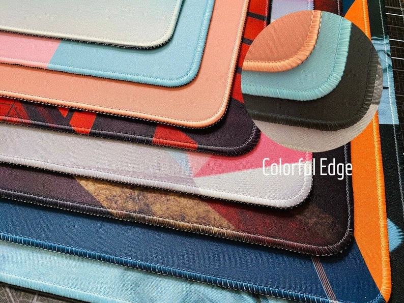 May include: Close-up of several colorful mouse pads with stitched edges. The pads feature various designs, including geometric patterns and solid colors. The text "Colorful Edge" is visible.